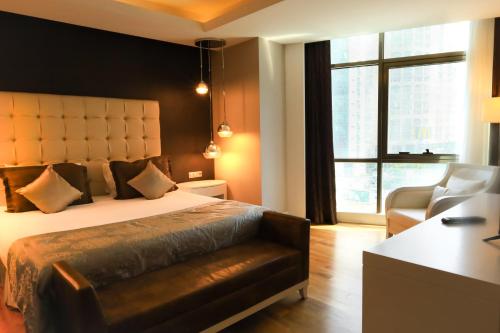 ein Schlafzimmer mit einem Bett und einem Stuhl und einem Fenster in der Unterkunft VIP Apartment & Residence Baku in Baku