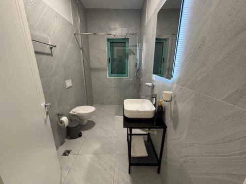 Un baño blanco con lavabo e inodoro. en Krist Room, en Dhërmi
