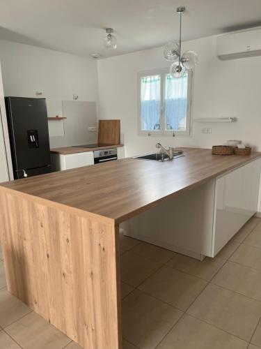 une cuisine avec un comptoir en bois dans une pièce dans l'établissement villa de vacance La Brillanne, à La Brillanne