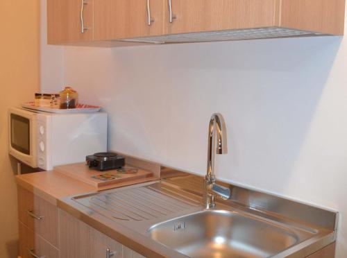 a kitchen with a sink and a microwave at Bilocale Giacomo Matteotti in Mazara del Vallo