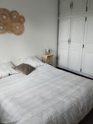 - une chambre avec un lit blanc et des armoires blanches dans l'établissement Pampounette, à Saint-Brévin-lʼOcéan