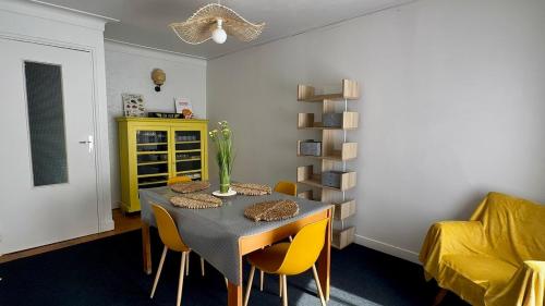 une salle à manger avec une table et des chaises jaunes dans l'établissement Maison Anatole France, à Cahors