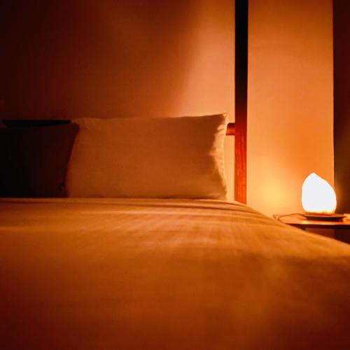 a bedroom with a bed with a pillow and a lamp at Kwale Residence in Zanzibar City