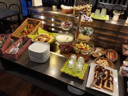 un buffet con muchos tipos diferentes de comida en una mesa en BRIT Hotel - Montsoult La Croix Verte, en Baillet-en-France