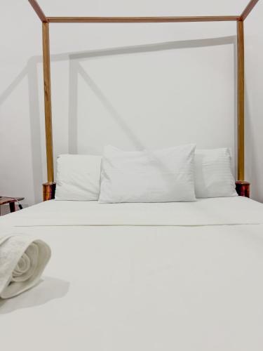 a white bed with a white blanket and pillows at Kwale Residence in Zanzibar City