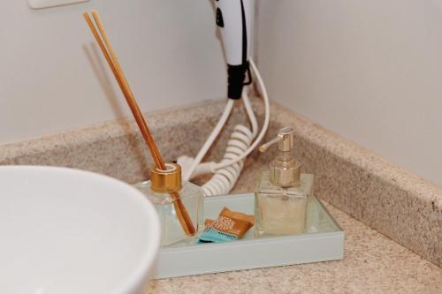 a bathroom counter with two bottles and a sink at Encontro dos Vales in Visconde De Maua