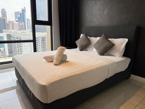a large bed in a room with a large window at GriffinS Grove at Axon Residence Bukit Bintang in Kuala Lumpur