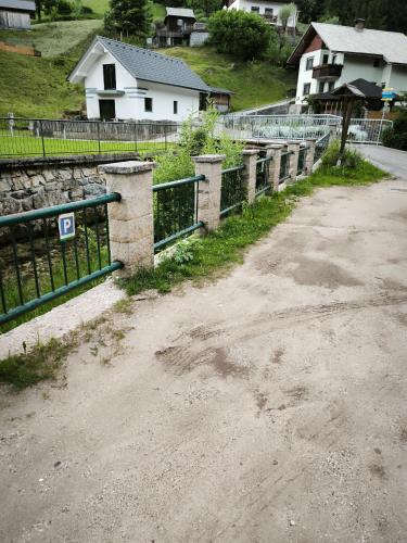 a dirt road with a fence and a house at Apartment Tarman in Jesenice