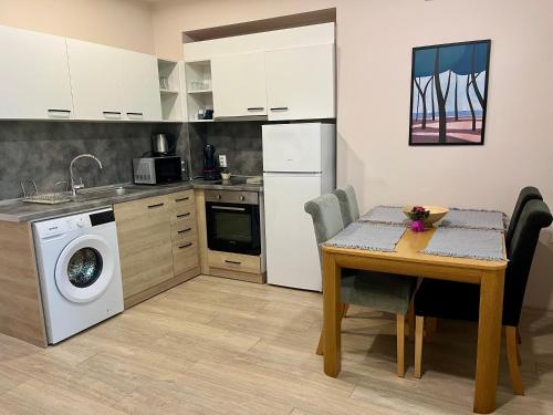 a kitchen with a table and a washing machine at Studio Thermi 1 in Varna City
