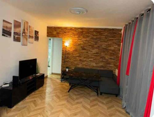 un salon avec un canapé et un mur de briques dans l'établissement Love House 4, à Aulnay-sous-Bois