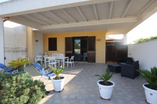 a patio with a table and chairs and plants at La casetta di Gabry - Torre Specchia Ruggeri in Torre Specchia Ruggeri