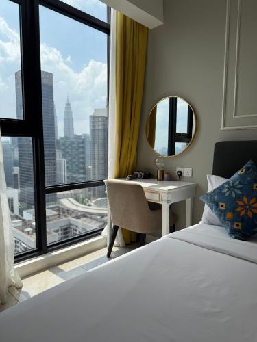 a bedroom with a bed and a desk and a window at GriffinS Grove at Axon Residence Bukit Bintang in Kuala Lumpur