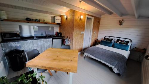 a bedroom with a bed and a wooden table at The Cosy Cabin in Portree