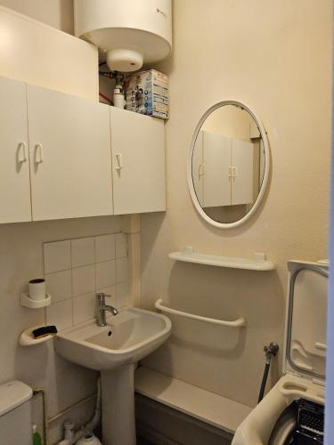 une salle de bain avec un lavabo et un miroir dans l'établissement Pétanque at 52 air conditioning, au Barcarès