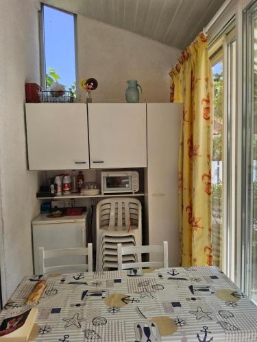 une petite cuisine avec une table et des chaises dans une pièce dans l'établissement Pétanque at 52 air conditioning, au Barcarès
