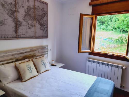 a bedroom with a bed with a window and a map on the wall at Casa MARIO y MARIOLA in El Dueso