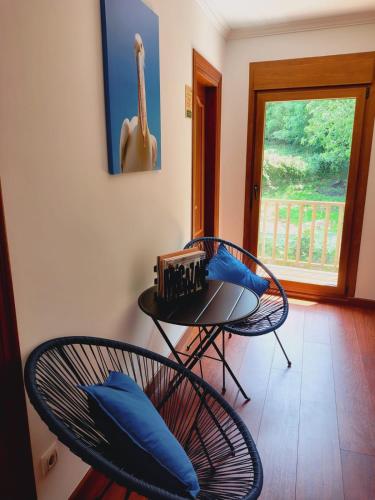 a room with two chairs and a table with blue pillows at Casa MARIO y MARIOLA in El Dueso