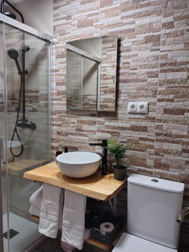 a bathroom with a sink and a glass shower at Casa MARIO y MARIOLA in El Dueso