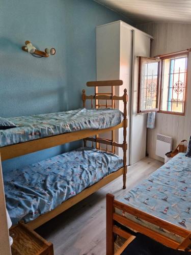 une chambre avec deux lits superposés et une fenêtre dans l'établissement Pétanque at 52 air conditioning, au Barcarès