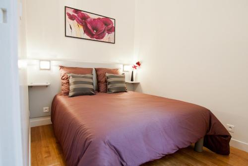 une chambre avec un grand lit dans une pièce dans l'établissement Elégant appartement Proche Champs Elysées, à Paris