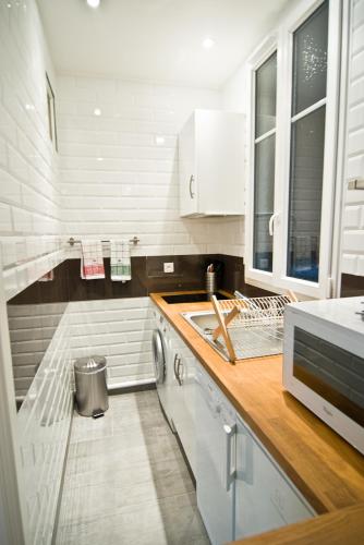 une cuisine avec un évier et une machine à laver dans l'établissement Elégant appartement Proche Champs Elysées, à Paris