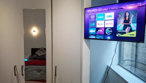 a flat screen tv on a wall in a room at GORGEOUS FlatD Central London Liverpool St Station in London