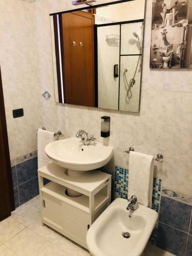 a bathroom with a sink and a toilet and a mirror at Casa Eraclea Venice in Eraclea