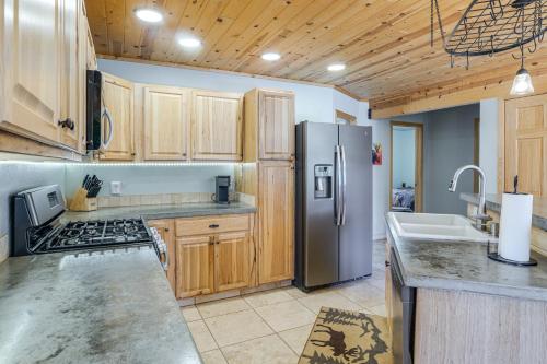 a kitchen with wooden cabinets and a stainless steel refrigerator at 8 Mi to Staunton State Park Mtn-View Hideaway! in Conifer