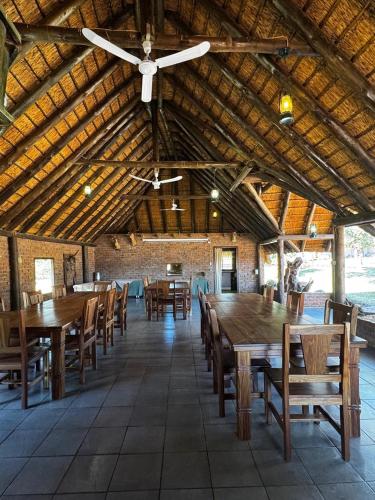a large dining room with wooden tables and chairs at Welgedacht Lodge in Cullinan