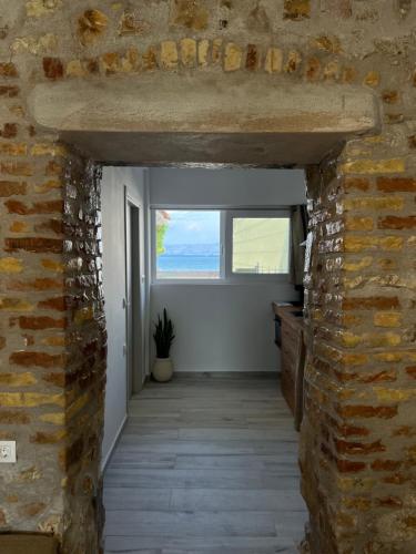 a hallway with a brick wall and a window at Greco Mare in Kavos