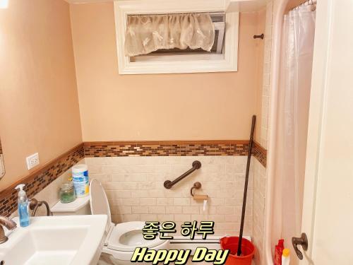 a bathroom with a happy day sign next to a toilet at Convenient & Cozy Stay Near Boston in Andover