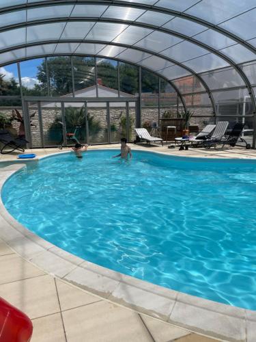 une grande piscine avec un toit en dôme dans l'établissement La traboule, à La Tranche-sur-Mer