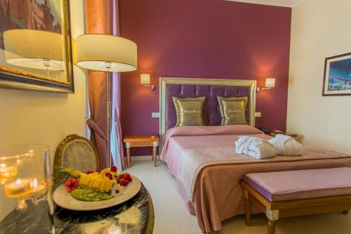 a hotel room with a bed and a table with a plate of fruit at Hotel Parco delle Fontane in Siracusa