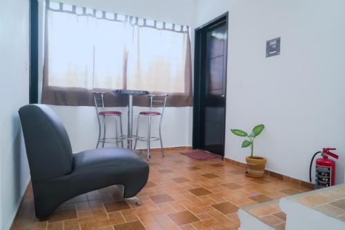 a living room with a chair and a table at Departamentos "GARCÍA LÓPEZ" es amplio muy acogedor 2 dormitorios y cerca del Auditorio Guelaguetza in Oaxaca City