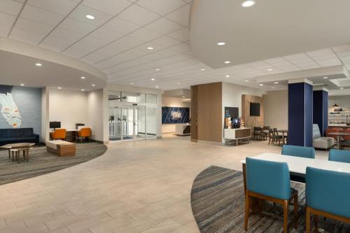 a lobby with a waiting area with a table and chairs at Holiday Inn Express Fort Lauderdale Airport South by IHG in Dania Beach