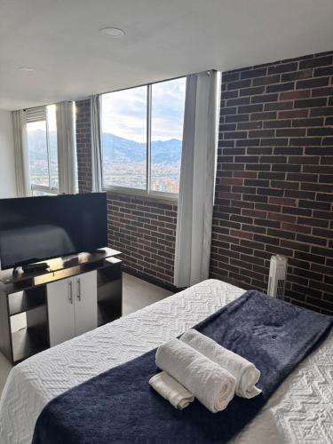 a bedroom with a bed with two towels on it at 2211 Despierta en poblado Medellín - Vista panorámica in Medellín