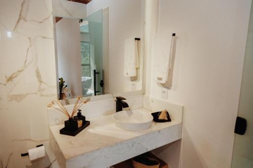 a white bathroom with a sink and a mirror at Encontro dos Vales in Visconde De Maua