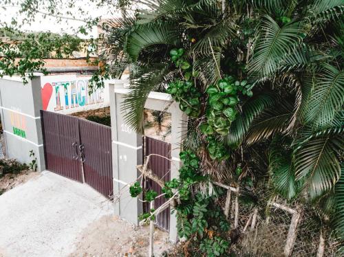 a fence with a palm tree in front of a building at Pousada Vila Baiana in Itacaré