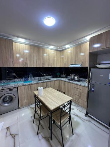 une petite cuisine avec une table et un réfrigérateur dans l'établissement New modern apartment Saidia, à La Celle-sous-Gouzon