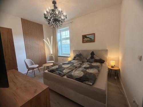 a bedroom with a large bed and a chandelier at Haus Burmeister in Sassnitz