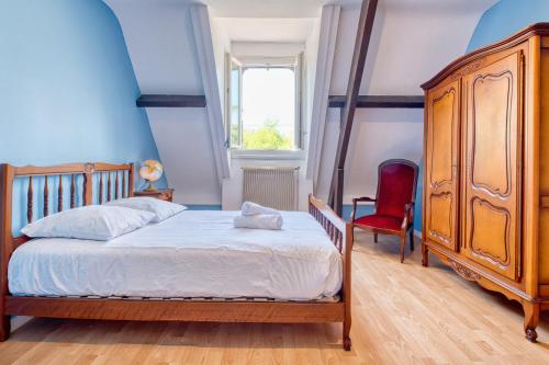 a bedroom with a wooden bed and a red chair at Le quai secret 