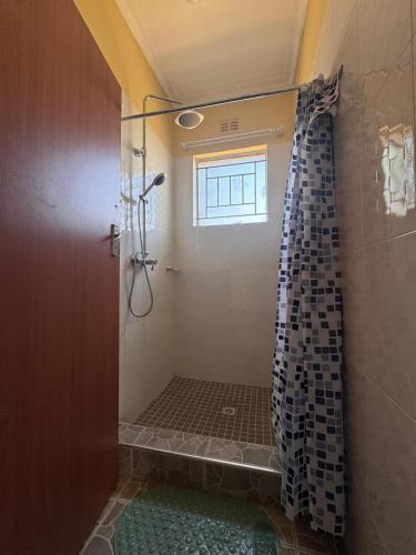 a bathroom with a shower with a window at Takonda BnB in Zomba