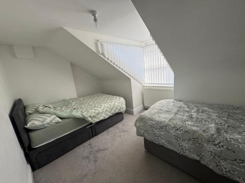 a bedroom with two beds and a staircase at Bay Walk Place in Morecambe
