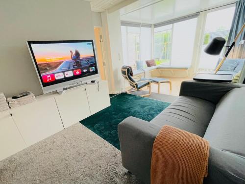 Una sala de estar con un sofá y un televisor de pantalla plana. en Floien City Apartment -Free parking, en Bergen