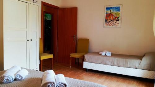 a room with two beds and a door with a window at Medoro Piazza Roma Rooms in Milazzo