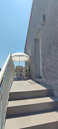 un patio avec une table et un parasol dans l'établissement Haut de villa, à Cervione