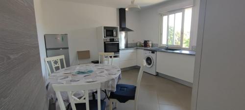 une cuisine avec une table et une cuisine avec une table et des chaises dans l'établissement Haut de villa, à Cervione