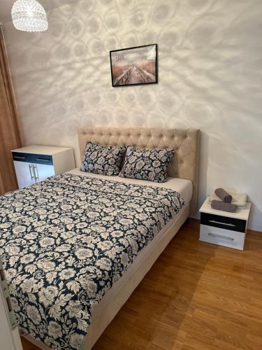 une chambre avec un lit avec une couette noire et blanche dans l'établissement Z&G apartman, à Bijeljina