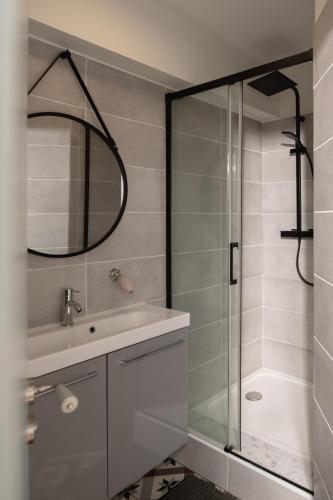 une salle de bain avec un lavabo et une douche avec un miroir dans l'établissement Maison Valentine, à Castelnau-sur-lʼAuvignon