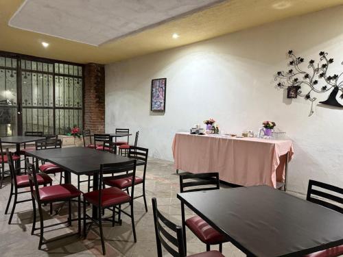 a restaurant with tables and chairs with pink table cloth at Hotel Hacienda Tonalmain, Central Nueva in Guadalajara